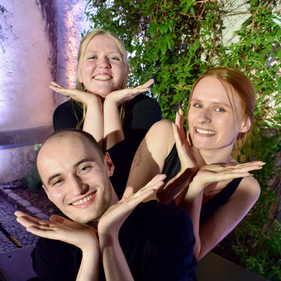 Jule, Lucia und Jakob posieren fröhlich mit den Händen unter dem Kinn